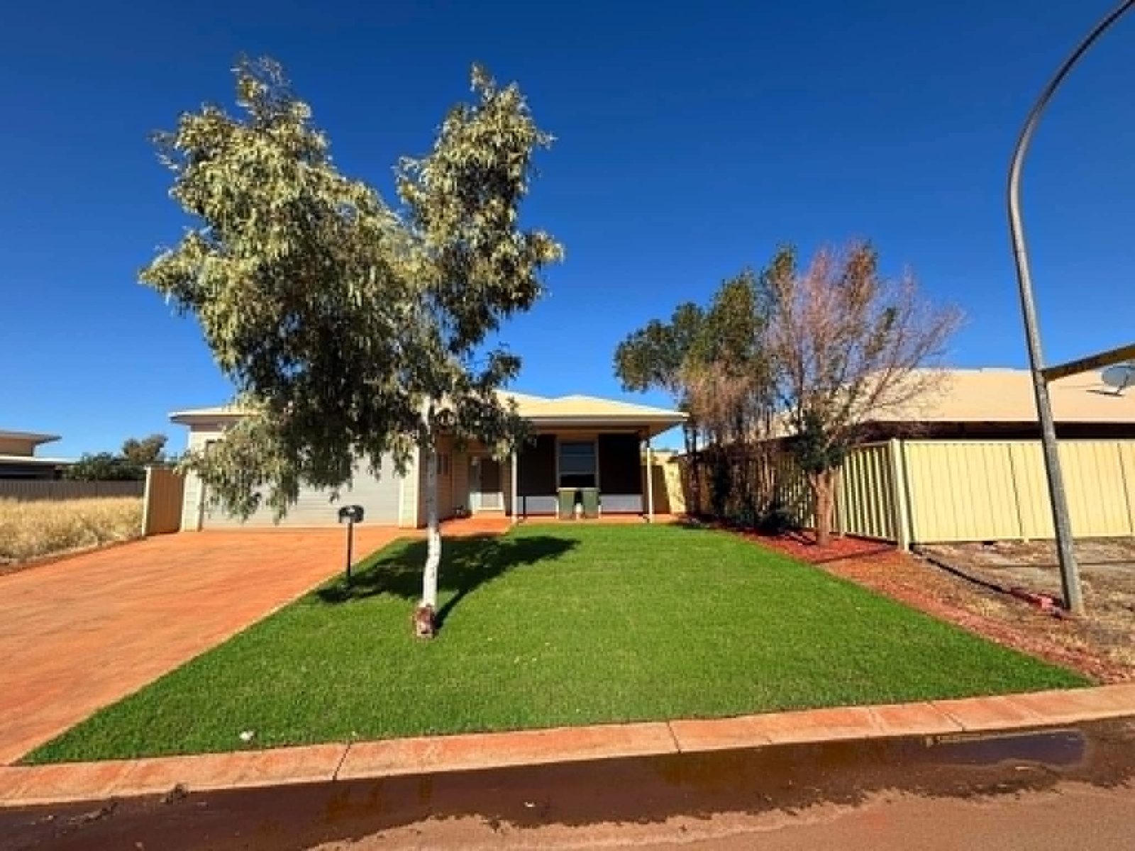 The same front yard with healthy green lawn after turf was laid