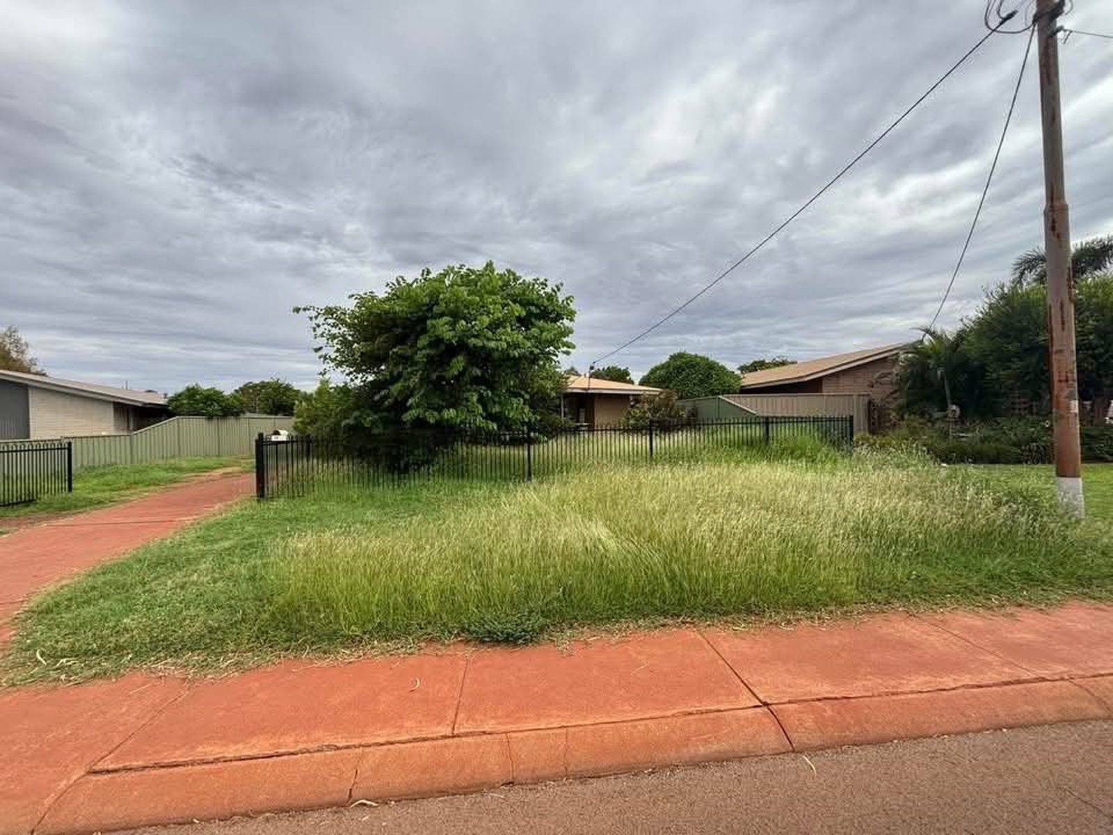 Overgrown front lawn and verge in Newman before mowing